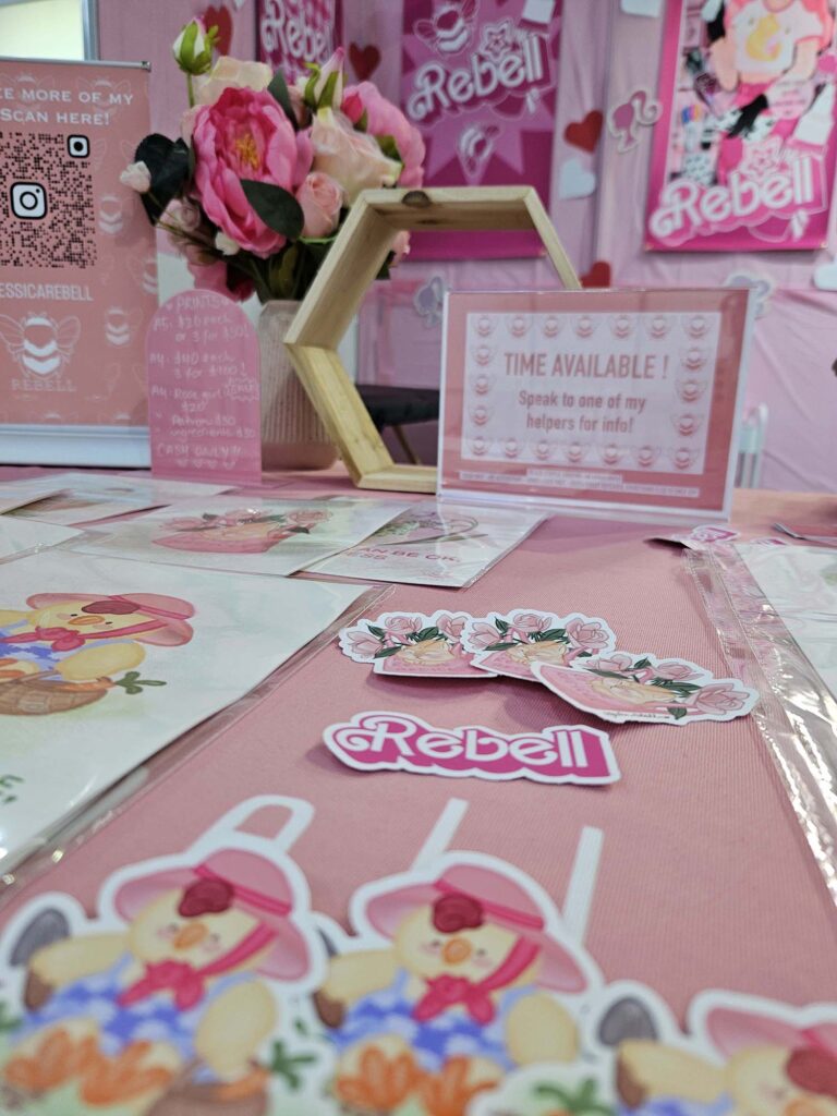 'Rebell' sticker with some postcards at an expo booth